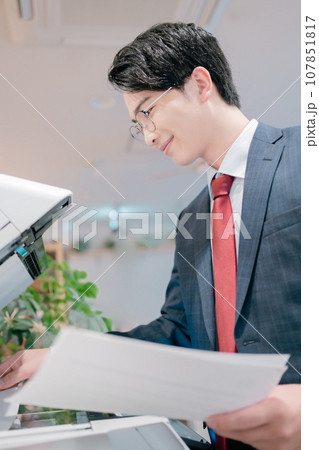 コピー機の前に立つ若い男性 コピー機の前に立つ若い男性 107851817