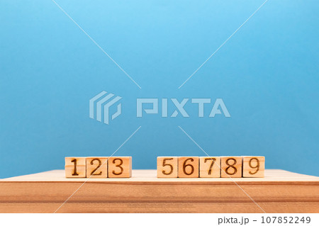 4が抜けていて1から9までの数字が木の台に並ぶ奥行き感がある青い背景 107852249