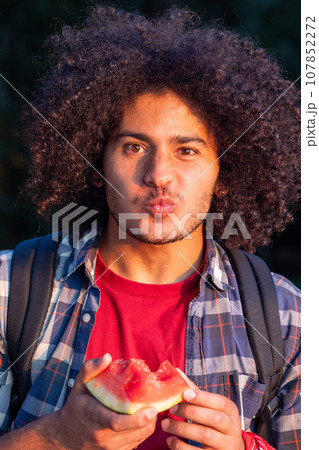 Arabian Man Enjoying Watermelon at Sunset Arabian Man Enjoying Watermelon at Sunset 107852272