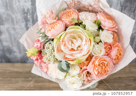 Small Beautiful bouquet of mixed flowers in woman hand. Floral shop concept . Beautiful fresh cut bouquet. Flowers delivery 107852957