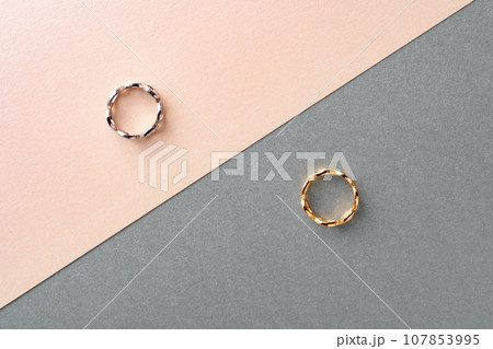 Two golden hoop earrings on paper background Two golden hoop earrings on paper background 107853995