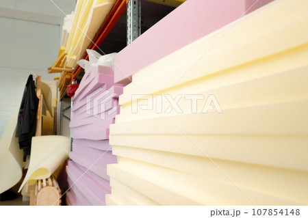 Stacked sheets of foam rubber for furniture production in factory workshop Stacked sheets of foam rubber for furniture production in factory workshop 107854148