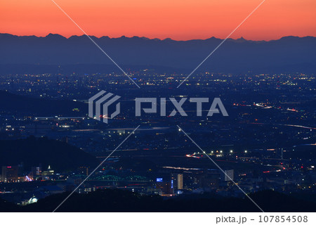 大小山から見る夕暮れの足利市、北関東の夜景と遠くシルエットの北アルプス穂高連峰と槍ヶ岳 107854508