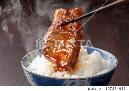 焼き肉と温かいご飯を一緒に食べるシーン 107854911