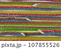Texture of the marmalade strips, lined with rows of bright red-green-blue flowers, is sprinkled with sugar. 107855526