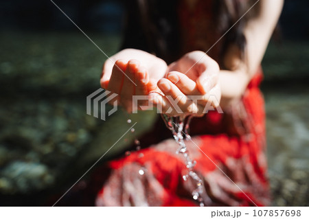 渓流の水をすくう若い女性 107857698