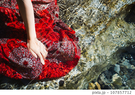 渓流の水をすくう若い女性 107857712