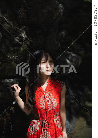 岩の前で光を浴びる女の子 107857837