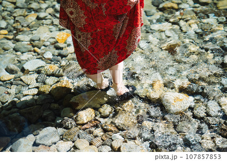 渓流に立つ赤いドレスを着た女性 107857853