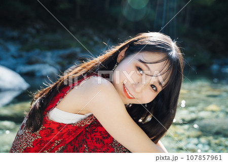 渓流の岩場に座る女性 107857961