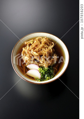 カマボコ、小ねぎの乗ったかき揚げ蕎麦、天ぷら蕎麦を黒背景で俯瞰撮影 107858203