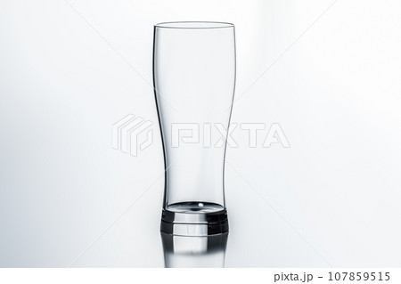 One empty glass. tall empty glass isolated on white. Empty glass for water, juice or beer. crystal utensil for beverage serving One empty glass. tall empty glass isolated on white. Empty glass for water, juice or beer. crystal utensil for beverage serving 107859515