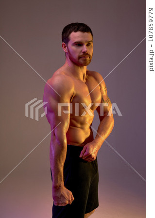 young sportsman with strong muscular arms demonstrates his body 107859779