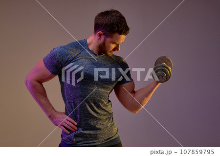 sportsman with perfect body exercising with dumbbell against brown background sportsman with perfect body exercising with dumbbell against brown background 107859795