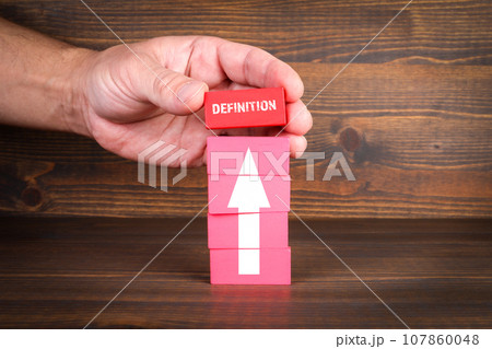 Definition Concept. Red blocks in a pile on a wooden texture background Definition Concept. Red blocks in a pile on a wooden texture background 107860048