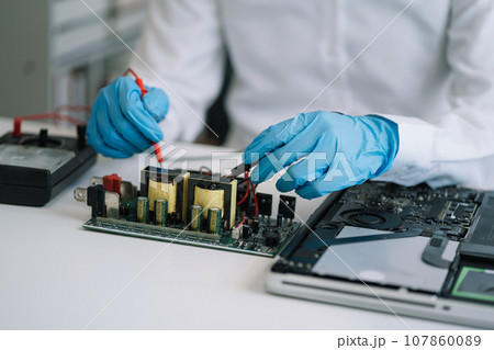 Hands repairing electronic devices. Electronic technician. 107860089