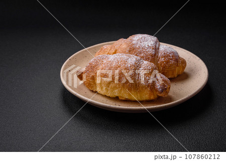 Delicious fresh sweet crispy croissants with chocolate cream on a ceramic plate Delicious fresh sweet crispy croissants with chocolate cream on a ceramic plate 107860212