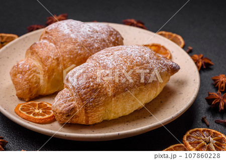 Delicious fresh sweet crispy croissants with chocolate cream on a ceramic plate 107860228
