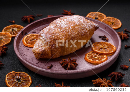 Delicious fresh sweet crispy croissants with chocolate cream on a ceramic plate 107860252