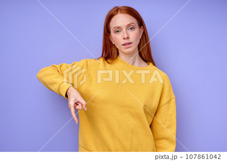 beautiful redhead serious girl, teacher showing letter Q on blue background beautiful redhead serious girl, teacher showing letter Q on blue background 107861042