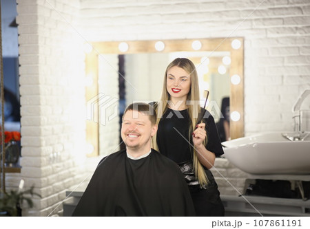 Pretty professional female master holding brush for modeling hairstyle 107861191