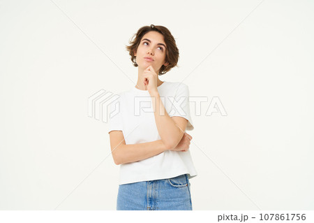 Portrait of thinking girl, smiling and pondering, making decision, contemplating something, standing over white background 107861756