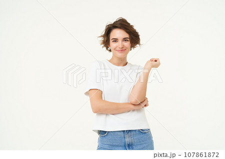 Portrait of woman standing in power pose, confident expression, cross arms on chest and smiles, stands over white background 107861872