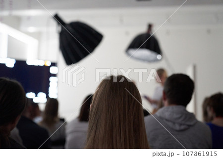 Unrecognizable people are sitting with their backs in the hall. I'm sitting at a lecture or a meeting at the university. business and entrepreneurship or the concept of learning. High quality photo Unrecognizable people are sitting with their backs in the hall. I'm sitting at a lecture or a meeting at the university. business and entrepreneurship or the concept of learning. High quality photo 107861915