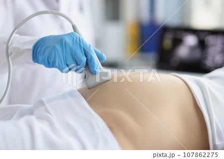 Gynecologist doing ultrasound scan on belly, doctor examining womans baby Gynecologist doing ultrasound scan on belly, doctor examining womans baby 107862275