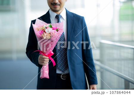 花束を持つスーツの男性　 107864044