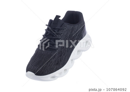 Black sneaker made of fabric with a white sole on a white shoe. 107864092