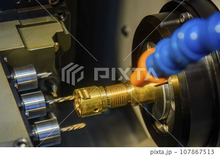 The multi tasking CNC lathe machine swiss type drilling the brass fitting parts. The multi tasking CNC lathe machine swiss type drilling the brass fitting parts. 107867513