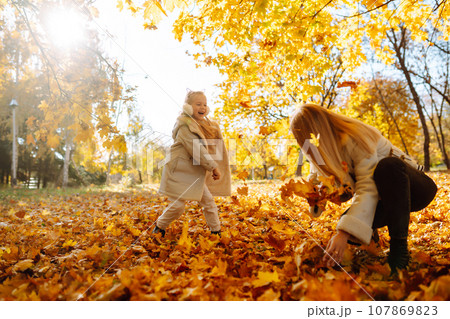 Portrait of happy mother and daughter in autumn forest at sunset. Autumn women. 107869823