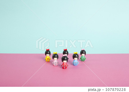 a collection of wooden kokeshi dolls arranged in a triangle like bowling skittles a collection of wooden kokeshi dolls arranged in a triangle like bowling skittles 107870228