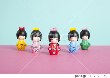 a collection of wooden kokeshi dolls arranged in a triangle like bowling skittles a collection of wooden kokeshi dolls arranged in a triangle like bowling skittles 107870230