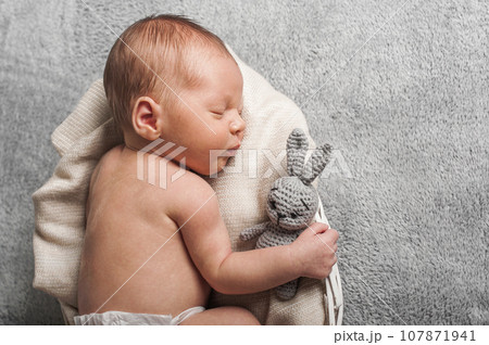 Newborn 3 weeks sleeping with rabbit toy close up. Baby care, colic, teething, healthy sleep.. 107871941