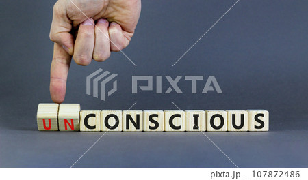 Conscious or unconscious symbol. Concept words Conscious Unconscious on wooden blocks. Beautiful grey table grey background. Psychologist hand. Psychology conscious or unconscious concept. Copy space. 107872486