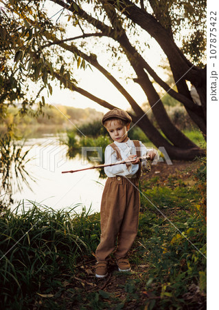 Little boy fishing at sunset 107875422