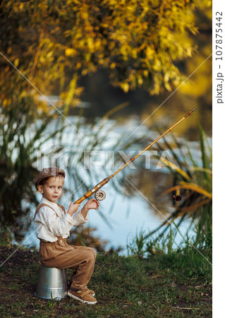 Child fishing at autumn lake Child fishing at autumn lake 107875442