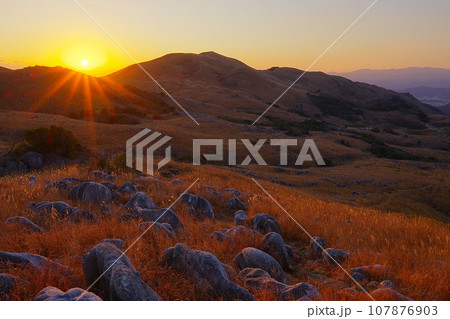 冬晴れの空を背景に北九州平尾台カルスト台地羊群原と日の出の風景_Ver2 107876903