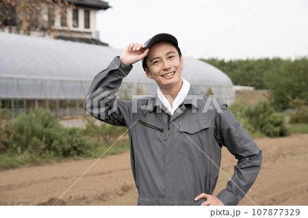 ビニールハウスと笑顔の農家の男性 ビニールハウスと笑顔の農家の男性 107877329