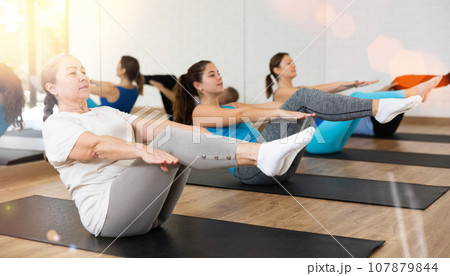 Elderly woman practicing pilates on mat in gym...の写真素材 [107879844] - PIXTA