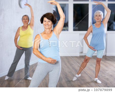 Group of elderly woman dancing in fitness studio Group of elderly woman dancing in fitness studio 107879899