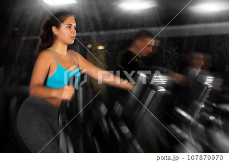 Fitness woman in sportswear doing cardio training on ellipsoid in gym Fitness woman in sportswear doing cardio training on ellipsoid in gym 107879970