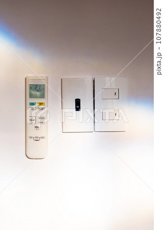 Air conditioner remote control hanging on wall. Air conditioner remote control hanging on wall. 107880492