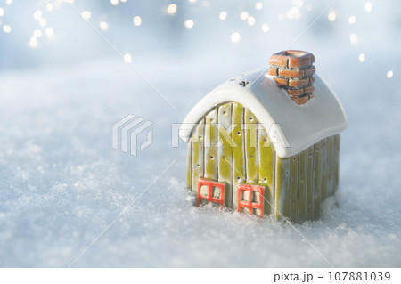 Toy house on snow, natural abstract background. winter season concept. Toy house on snow, natural abstract background. winter season concept. 107881039