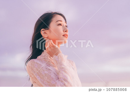 夕日に染まる女性のビューティーイメージ 107885008