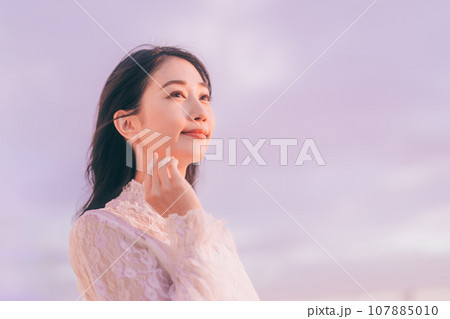 夕日に染まる女性のビューティーイメージ 107885010