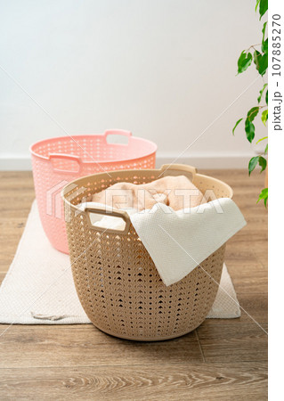 Pile of clothes in plastic laundry basket in the bathroom 107885270