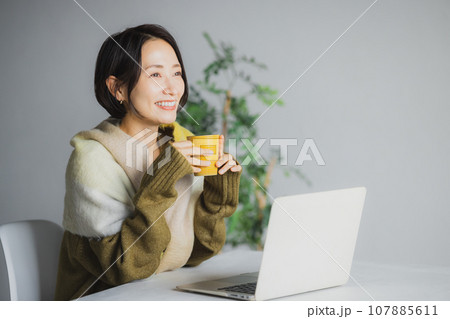 コーヒーを飲みながらパソコンを見る女性 107885611
